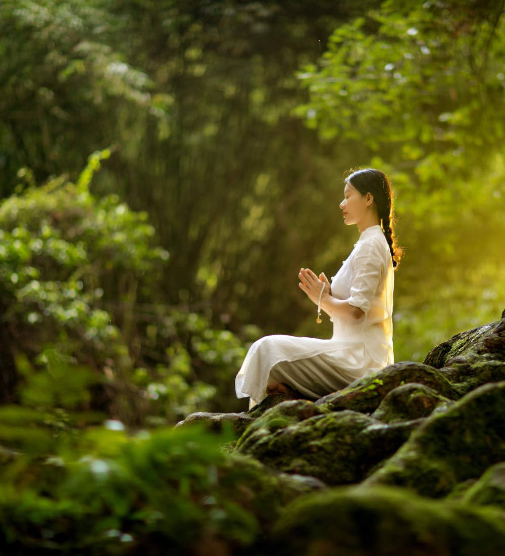 Eine Frau im Wald meditiert